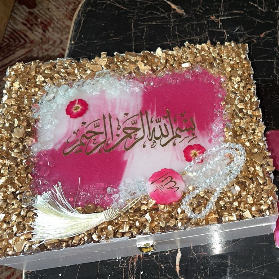 Decorative item with gold and pink design on a dark surface